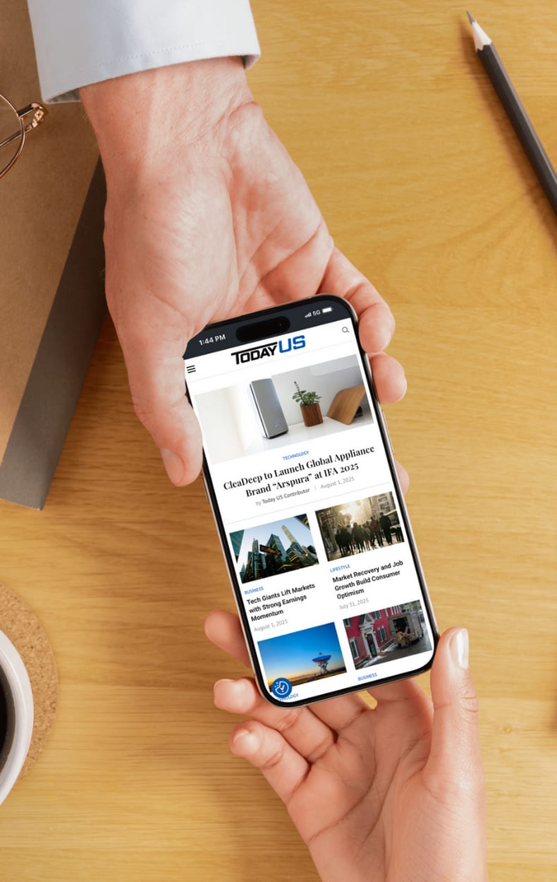 A hand holding a phone showing a Today US article.